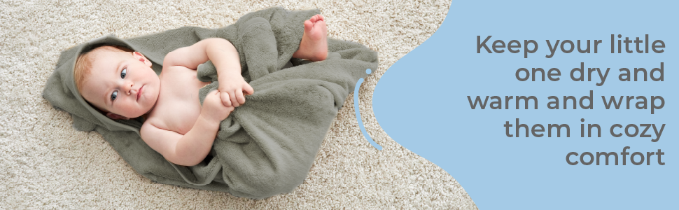 Child wrapped in cozy comfort enjoying post bath joy on the floor - perfect baby shower gift