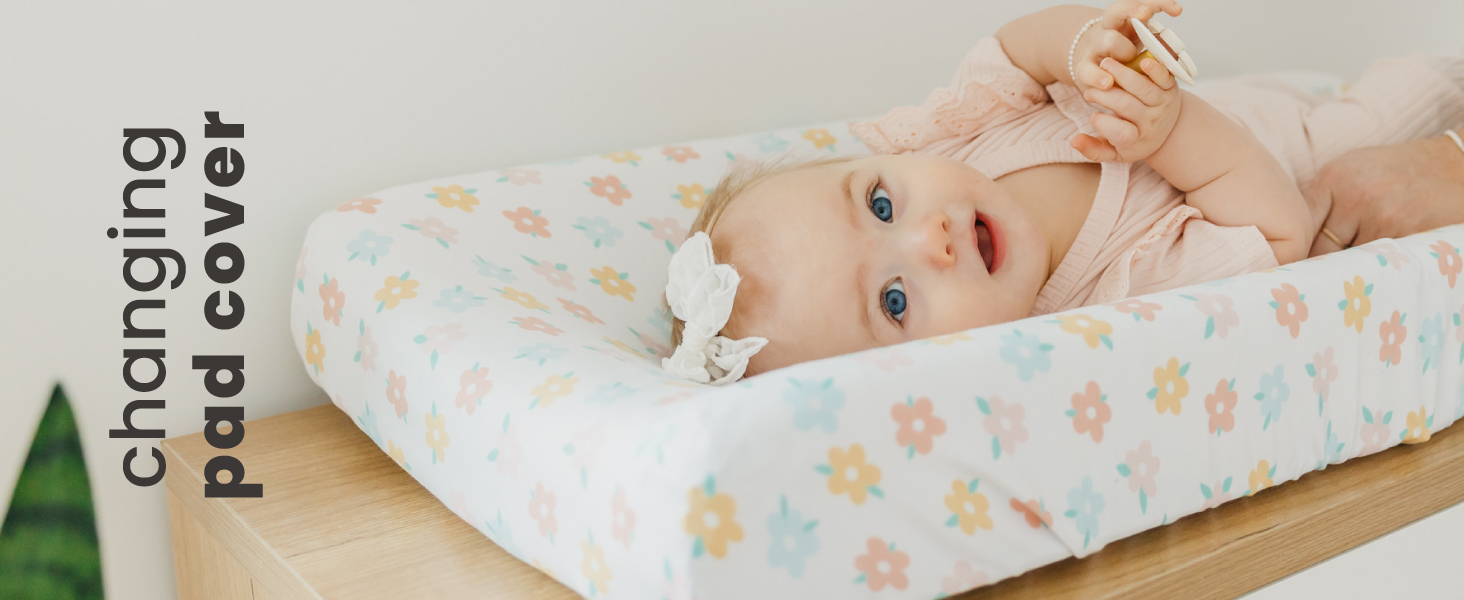 baby laying on changing pad with a floral print cover